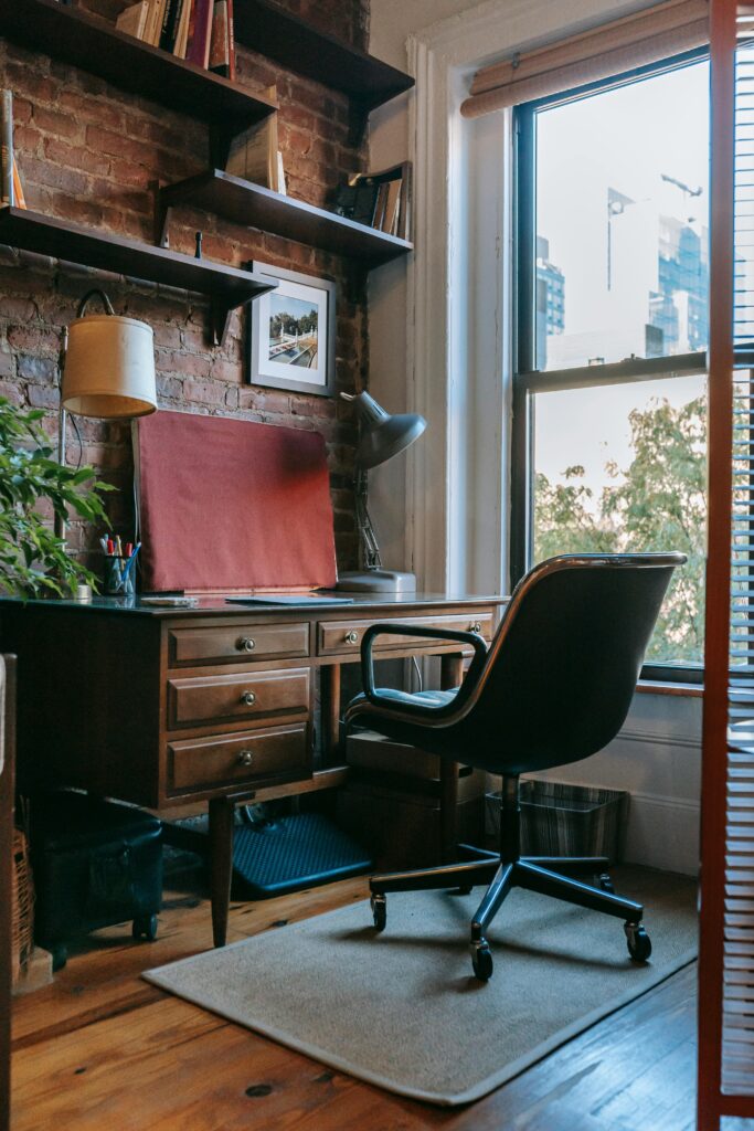Comfortable room with shelves hanging on brick wall near large window in daylight
