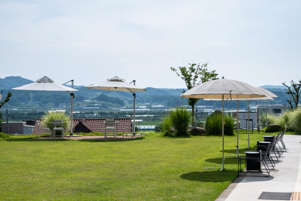 Scenic outdoor resort patio with umbrellas and mountain backdrop.